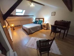 um quarto com uma cama, uma secretária e um piano em La Fermette Aux Lamas em Savigny-Lévescault