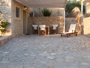 een patio met stoelen en een tafel voor een gebouw bij Poliana Estate Studios in Kotrónion