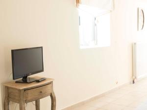 a television on a wooden table in a room at Poliana Estate Studios in Kotrónion