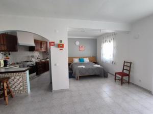 eine Küche und ein Schlafzimmer mit einem Bett in einem Zimmer in der Unterkunft Apartamentos Campos 1 in Porto Covo