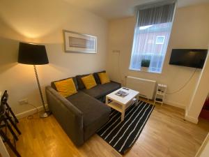 uma sala de estar com um sofá e uma mesa em Midland Apartments- one bedroom em Leicester