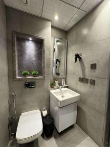 a bathroom with a white toilet and a sink at The Opulence Suite 41st Floor City View in Noida