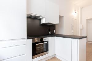 uma cozinha com armários brancos e um fogão em Nice apartment 2 bedrooms in Old Lille! em Lille