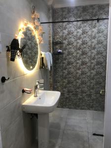 a bathroom with a sink and a shower with a mirror at Yacoubian Suites in Cairo