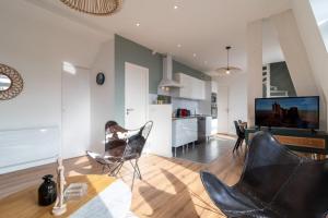 a living room with black chairs and a kitchen at Marcq en Baroeul - Superb apartment + parking in Marcq-en-Baroeul