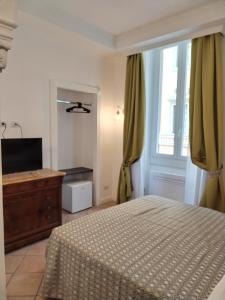 um quarto com uma cama, uma cómoda e uma janela em B&B L'Esquilina em Roma