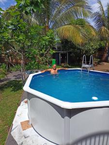 a man laying in a bath tub in a swimming pool at Chez Chouchou in Rivière