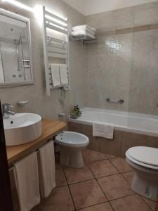 a bathroom with a sink and a toilet and a tub at B&B L'Esquilina in Rome