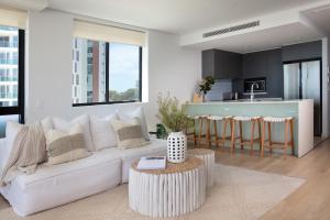 een woonkamer met een witte bank en een keuken bij Villa Sol - Luxury 3 Bedroom Villa in Kirra in Gold Coast