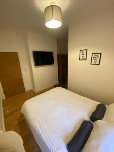 a bedroom with two beds and a flat screen tv at Midland Apartments- one bedroom in Leicester