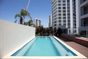 a swimming pool on the side of a building at Villa Sol - Luxury 3 Bedroom Villa in Kirra in Gold Coast