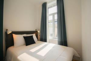 een slaapkamer met een groot bed en een raam bij Superb apartment near the Grand Place! in Lille