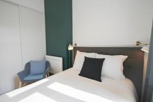 1 dormitorio con 1 cama y 1 silla azul en Superb apartment near the Grand Place!, en Lille