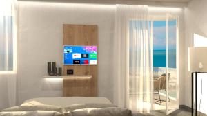 1 dormitorio con 1 cama y TV en la pared en Hotel Miramare Chioggia Sottomarina con PISCINA, en Sottomarina