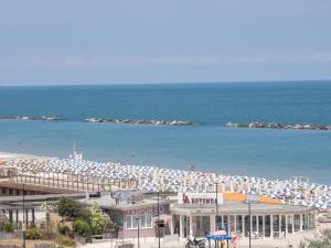 una spiaggia con molti ombrelloni e l'oceano di Hotel Marina Beach a Ravenna