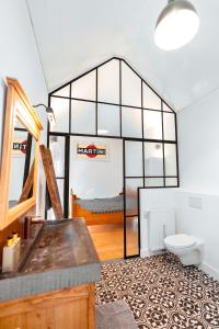 ein Bad mit WC und ein Bett in einem Zimmer in der Unterkunft Het Heidehuis in De Haan