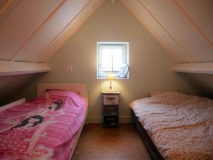 a attic bedroom with two beds and a window at Zeepolder I 45 in De Haan +7 photos
