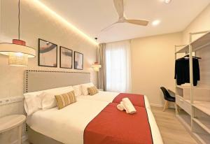 a bedroom with a bed and a ceiling fan at Soho Boutique Palillero in Cádiz