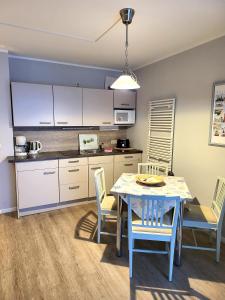 eine Küche und ein Esszimmer mit einem Tisch und Stühlen in der Unterkunft Ferienwohnungen am Rosenhof in Kühlungsborn