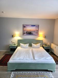 キュールングスボルンにあるFerienwohnungen am Rosenhofのベッドルーム1室(白い大型ベッド1台、テーブル2台付)