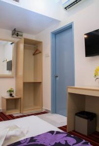 una camera da letto con porta blu e TV di bintang hotel a Kuala Lumpur