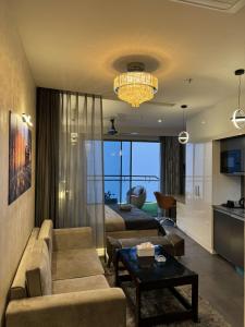a living room with a couch and a chandelier at The Opulence Suite 41st Floor City View in Noida