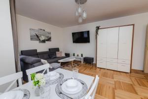 ein Wohnzimmer mit einem Tisch und einem Sofa in der Unterkunft EASY RENT Apartments- Bielskiego 1 24H-Check In in Lublin