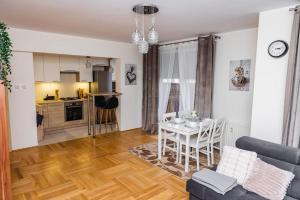 ein Wohnzimmer mit einem Tisch und einer Küche in der Unterkunft EASY RENT Apartments- Bielskiego 1 24H-Check In in Lublin
