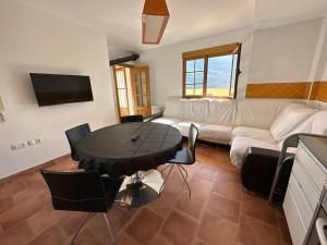 una sala de estar con una mesa y un sofá en Mirador de Sierra Nevada, en Güéjar-Sierra