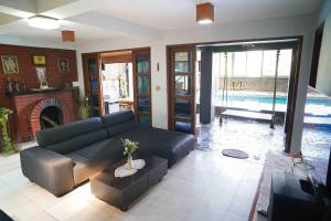 - un salon avec un canapé et une piscine dans l'établissement Pondok Sukamulus by GroRental, à Cihanjuang 1