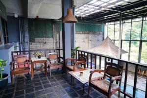 - un restaurant avec des tables et des chaises dans une salle dotée de fenêtres dans l'établissement Pondok Sukamulus by GroRental, à Cihanjuang 1