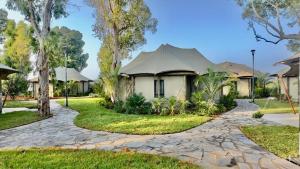 a house with a gravel driveway in front at Doga Resort - דוגה ריזורט in Kinar