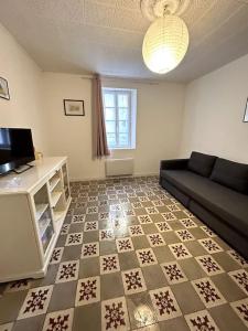 博凱爾的住宿－"Le N2" Beaucaire centre-ville，客厅配有黑色沙发和 ⁇ 格地板