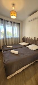 um quarto com 2 camas grandes com almofadas em Appart T3 a 50 m de la plage em Cavalaire-sur-Mer