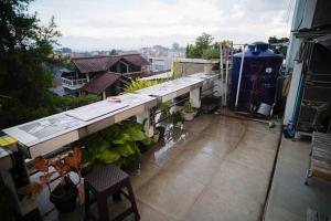 un balcón con una mesa y algunas plantas. en Schones Haus Private Pool & Netflix by GroRental, en Bandung