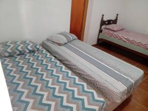een bed met een dekbed in een kamer bij Casa de campo agradável com piscina aquecida in Juatuba