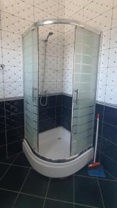 a shower with a glass door in a bathroom at Rooms for Rents in Kamëz