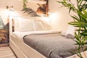 ein Schlafzimmer mit einem Bett mit weißen Kissen und Pflanzen in der Unterkunft Lille Grand-place : Functional and quiet studio ! in Lille