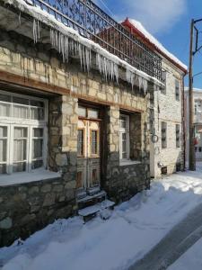 un edificio de piedra con carámbanos en la parte delantera en Anneta s StudioBear s Path, en Sklíthron