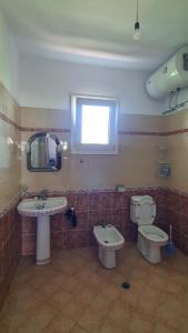 a bathroom with a sink and a toilet and a mirror at Rooms for Rents in Kamëz