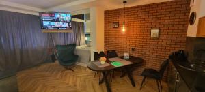 a room with a table and a brick wall at Happy time together apartament z Jacuzzi in Wojkowice