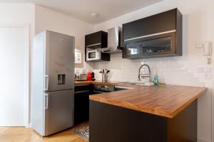 a kitchen with a refrigerator and a wooden counter top at Vieux Lille - center apartment! in Lille +12 photos