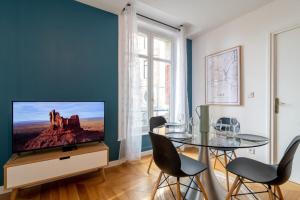 uma sala de estar com uma televisão e uma mesa com cadeiras em Vieux Lille - center apartment! em Lille