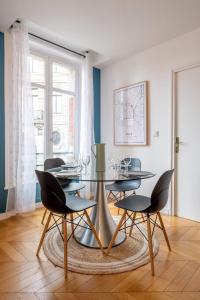 uma sala de jantar com uma mesa de vidro e cadeiras em Vieux Lille - center apartment! em Lille