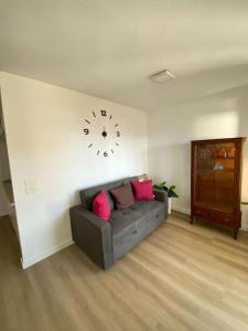 a living room with a couch and a clock on the wall at Apartamento Vista al mar in Dehesa de Campoamor +7 photos