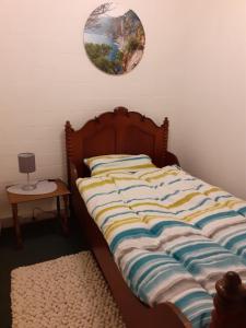 a bed in a bedroom with a clock on the wall at Ruhiges Ferienhaus im Garten in Bad Salzuflen