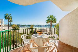 a table and chairs on a balcony with palm trees at E428 Anglada 54 by Mallorca Villa Selection in Alcudia