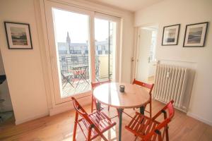 mesa y sillas en una habitación con ventana en Lille République-Nice and bright flat with Balcony, en Lille