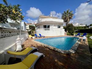 a villa with a swimming pool in front of a house at Vilamoura Brightness Villa With Pool by Homing in Vilamoura