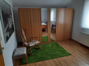a living room with a chair and a mirror at Ferienwohnung im Arfetal in Bad Berleburg